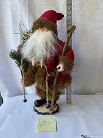 Santa figure facing forward showing full height with measuring stick and accessories including sack and wooden base.