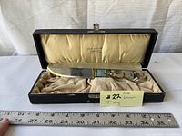 Knife in original fabric-lined box, showing knife length approx 8 inches alongside ruler, box lid visible with branding 'OLE AAS A/S GOLDMEDAL TRONDHEIM'