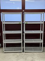Front view of two assembled 5-tier plastic shelving units side by side against a garage door, showing structure, height, and shelf spacing.