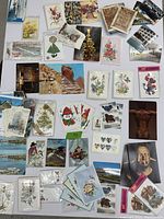 Photo showing a collection of assorted vintage cards spread out including Christmas, gift, art, and postcards mainly from 1970s Denmark. Includes images of Santa, flowers, sculptures, landmarks, and decorative elements.