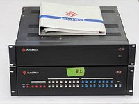 Two black rackmount units labeled AutoPatch iY-16 stacked, with control buttons and indicators visible on front panels, manual placed on top