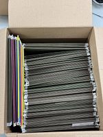 Top view of a box filled with various colored hanging file folders arranged neatly.