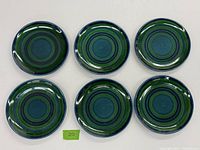 Top view of six ceramic plates showing blue and green concentric circle design.