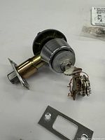 Front view of Schlage deadbolt with multiple keys inserted and attached by wire ring, along with mounting plate.