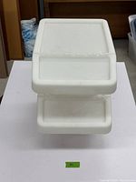 Two white plastic containers stacked, with tilt-top lid closed