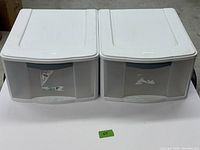 Two Sterilite plastic storage drawers side-by-side showing front view with gray front panels and white top with integrated handle.