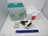 Vintage airplane-shaped kiddie car with original box, foam packaging and manual. Green body with white wings and red propeller.