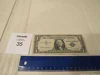 Front view of the 1957 series $1 Silver Certificate bill showing the portrait of George Washington, serial number C87832604A, and blue seal.