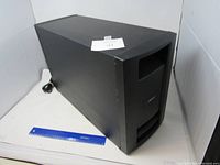 Full view of black rectangular Bose Model PS28 III powered speaker with power cable coiled beside it, showing overall shape and condition.