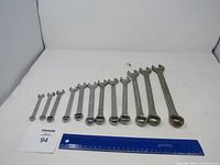 Photo showing the full set of 10 IH-Mac combination wrenches arranged by size from smallest to largest on a white backdrop next to a ruler.