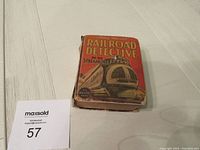 Small red book titled 'Railroad Detective The Streamliner' with front cover illustration of a streamlined train, showing condition and size.