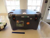 Wide side view of cooler placed indoors on table showing scale and condition including minor scuffs