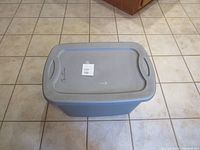 Top view of the plastic tote with closed lid showing the rectangular shape, handles, and the lot number sticker.