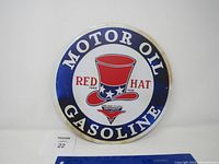 Front view of the round Red Hat Motor Oil Gasoline metal sign showing logo and text.