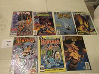 Seven Hawkman comic books arranged in two rows on a table, each in protective plastic sleeves.