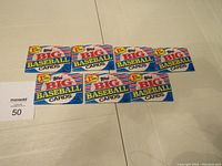 Seven unopened packs of Topps 1988 Big Baseball Cards laid out on a floor surface.