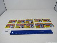 Ten unopened 1988 Topps Baseball Sticker Packs arranged in two rows with ruler for scale