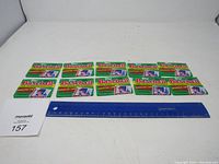 Ten unopened packs of 1990 Topps Baseball Yearbook Stickers laid out side by side with a ruler for scale.