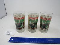 Three 1989 Kentucky Derby glasses with the event details and horse/jockey graphics visible, ruler for size reference.