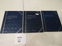 Three blue coin books titled Lincoln Head Cent, Jefferson Nickel, and Roosevelt Dime, arranged side by side on a white surface.