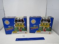 Two boxed GE 30-light outdoor transparent Christmas light sets side-by-side with holiday graphics visible on packaging.