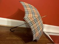 Umbrella open and leaning against wall, full view of canopy and handle