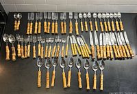 Overhead view of entire flatware collection including forks, knives and spoons arranged on countertop