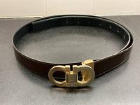Full belt coiled showing brown leather side and buckle