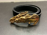 Rolled belt showing full leather strap and horse head buckle from front