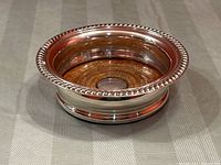 Angled view of full coaster showing metal band and wood base