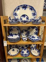 Wooden shelving with entire Alfred Meakin Belmont flow blue set arranged across multiple shelves