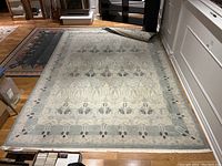 Full view of the Turkish area rug laid flat showing overall design, colors, and size relative to surroundings.