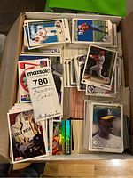 Box full of baseball cards stacked and spread interior showing various player cards from 1980s-1990s.
