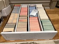 Box filled with neatly organized baseball cards in rows divided by color.