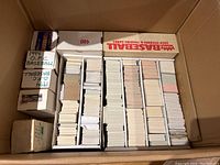 Large cardboard box containing 10 boxes of baseball cards stacked vertically, some labeled with years 1994 and brand O-Pee-Chee, and a factory sealed box.