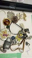 Full lot of assorted vintage costume jewelry including necklaces, brooches, rings, padlock, ticket, and Stratton compact