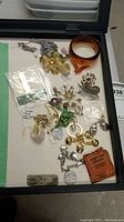 Overview of assortment of costume jewelry items including bracelets, brooches, earrings, pendants
