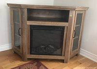 Front view of electric fireplace with side storage cabinets with beveled glass doors, and open shelf above insert.