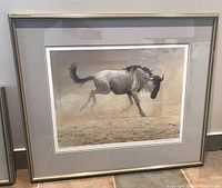 Full view of framed Robert Bateman print of wildebeest showing frame and matting