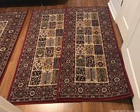 Two IKEA Valby Ruta runner rugs laid side by side, showing patchwork design and red border.