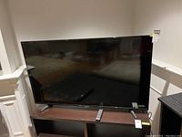 Front view of television on stand with remote control placed on top