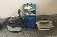 Photo showing Maximum shop vac, Mastercraft heater, Makita drill with case, and King Canada tile saw on countertop.