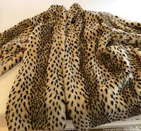 Faux leopard print plush coat showing full front with spotted animal pattern.