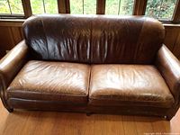 Front view of sofa showing distressed brown leather upholstery
