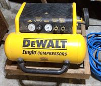 Top-front view of yellow DeWalt Emglo air compressor with pressure gauges and regulator controls visible