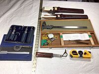 Overview of lot: 2 slide rules with sheaths, wooden caliper box, wooden box with gauge and tweezers, marking gauge, torpedo level, and zippered drafting instrument case.