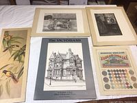 Top view of the lot showing multiple art prints and ephemera included in the collection placed on a white surface
