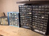 Four multi-drawer hardware storage organizers filled with assorted hardware and tools