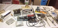 Full lot showing Steel Transfer Punch set, Handy Jack, rotary tool, screwdriver, metal discs, and assorted tools spread on table.