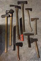 Top-down view of all tools laid out showing sledgehammers, axes, machete and hatchets